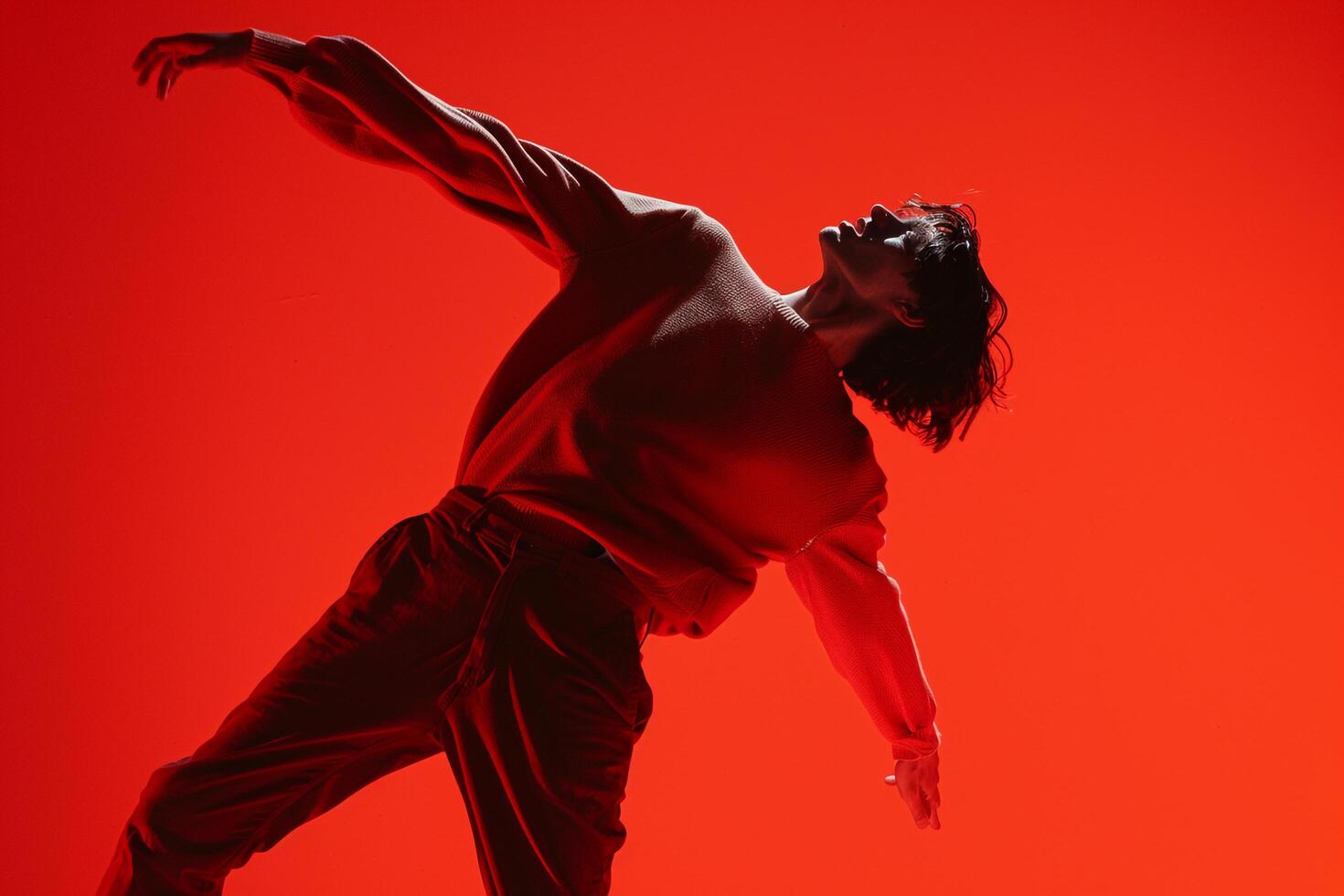 Fashionable male model in a sweater with a neon red background featuring a stylish appearance and an energetic lifestyle photo