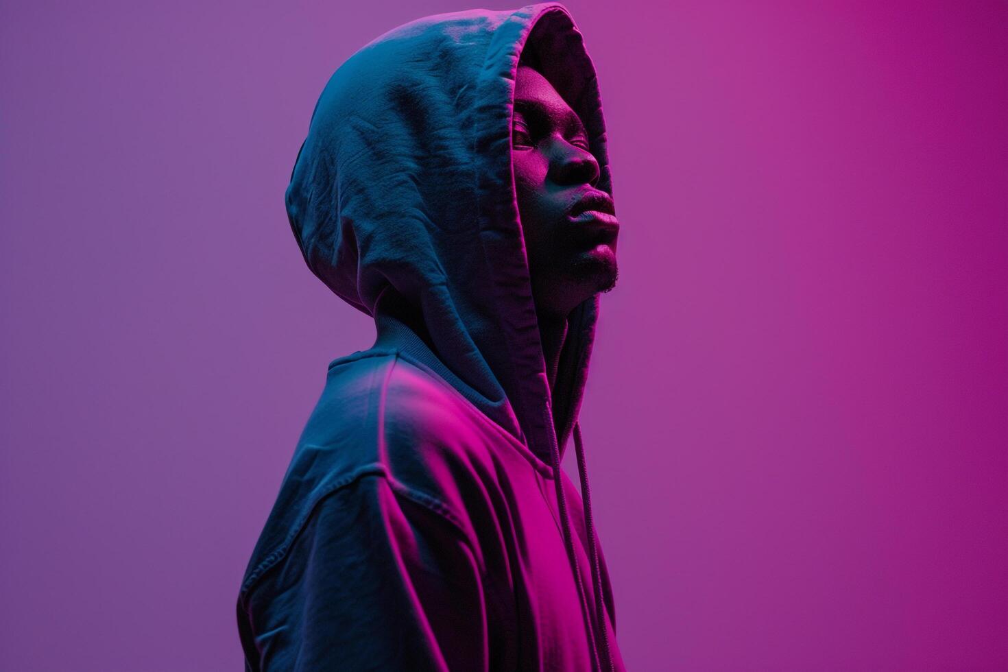 Stylish male fashion model in a hoodie with a royal purple background showcasing a chic fashion look and a modern lifestyle photo