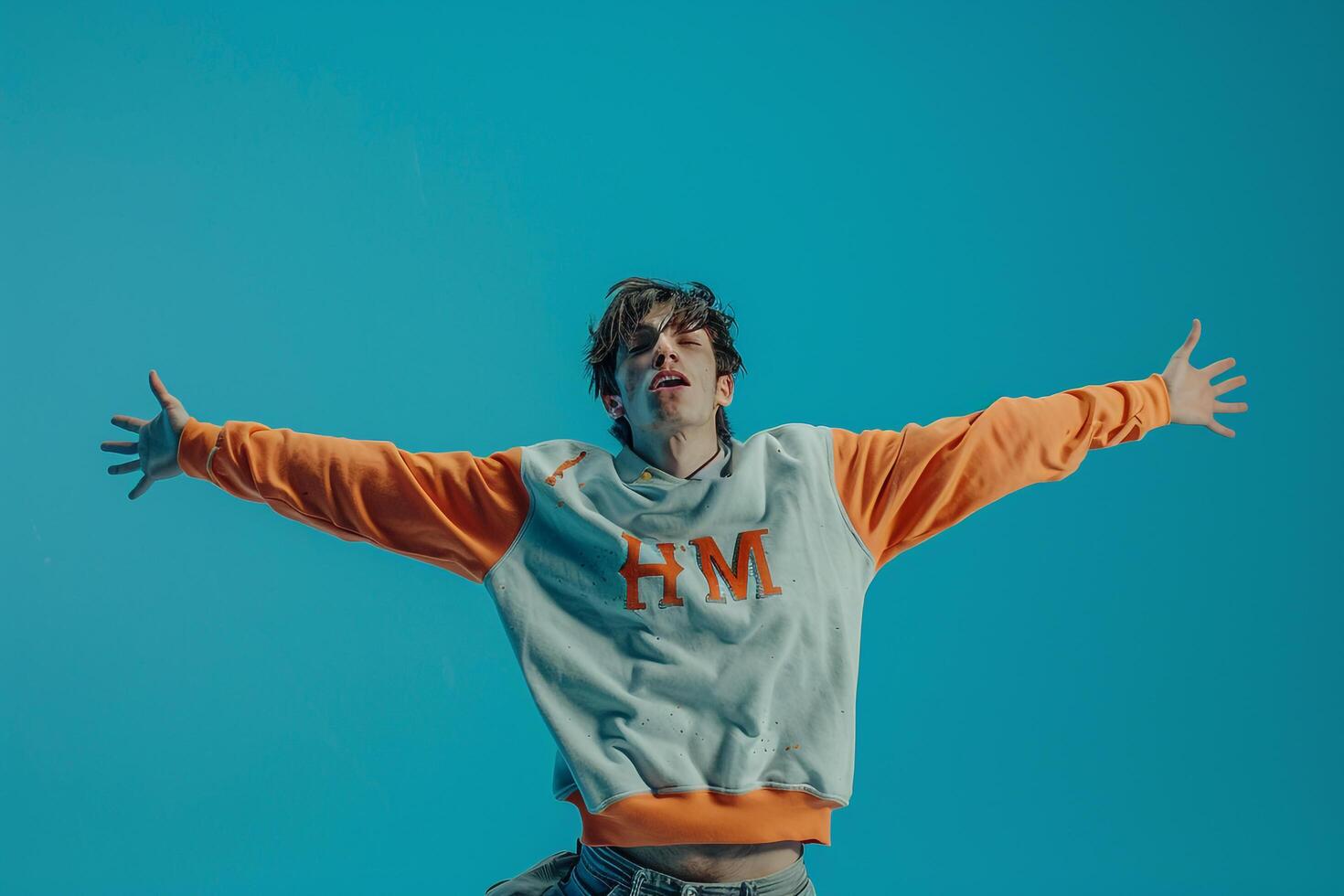 Stylish male fashion model in a sweatshirt with an aqua blue background highlighting a casual lifestyle and modern fashion portrait photo
