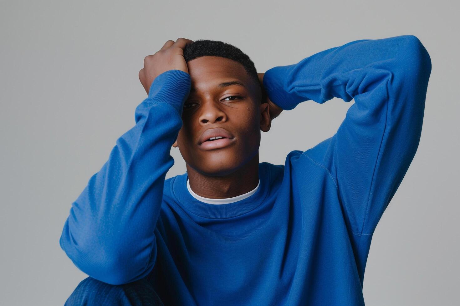 Bright Blue Crewneck Clad Male with pale Gray Background emphasizing Trendy Fashion in a Stylish Lifestyle portrait photo