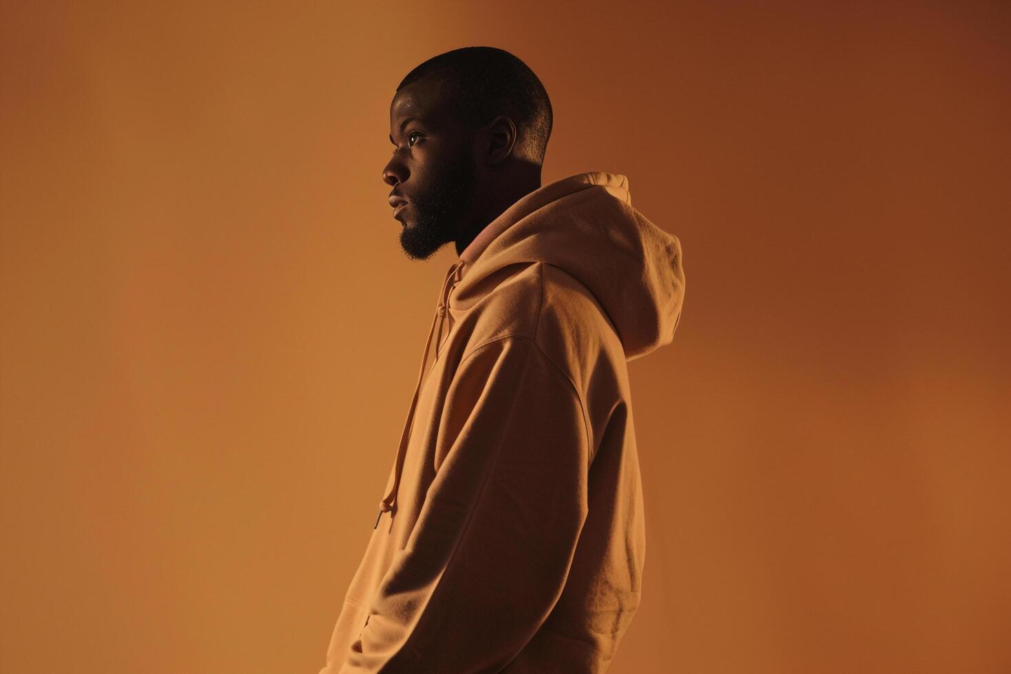 Burnt Orange Background with Hoodie Clad Male  Lifestyle portrait Highlighting Rich Contemporary Style and Fashionable Look photo
