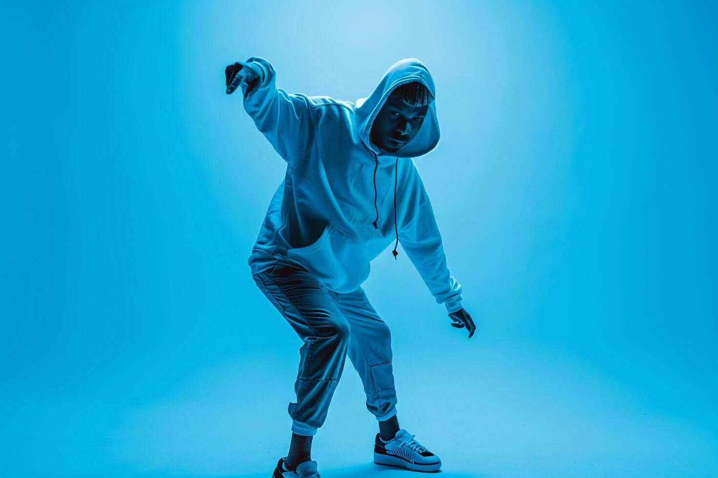 electric Blue Background with Hoodie Clad Male  Lifestyle portrait emphasizing Style and Vibrant Fashion Trends photo