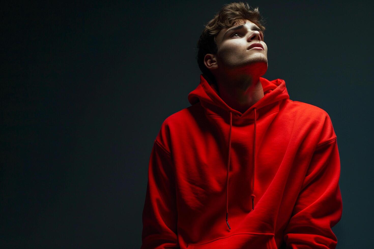 Bright Red Hoodie Clad Male with Midnight Black Background Lifestyle portrait Showcasing Fashion Trends and Bold Style photo