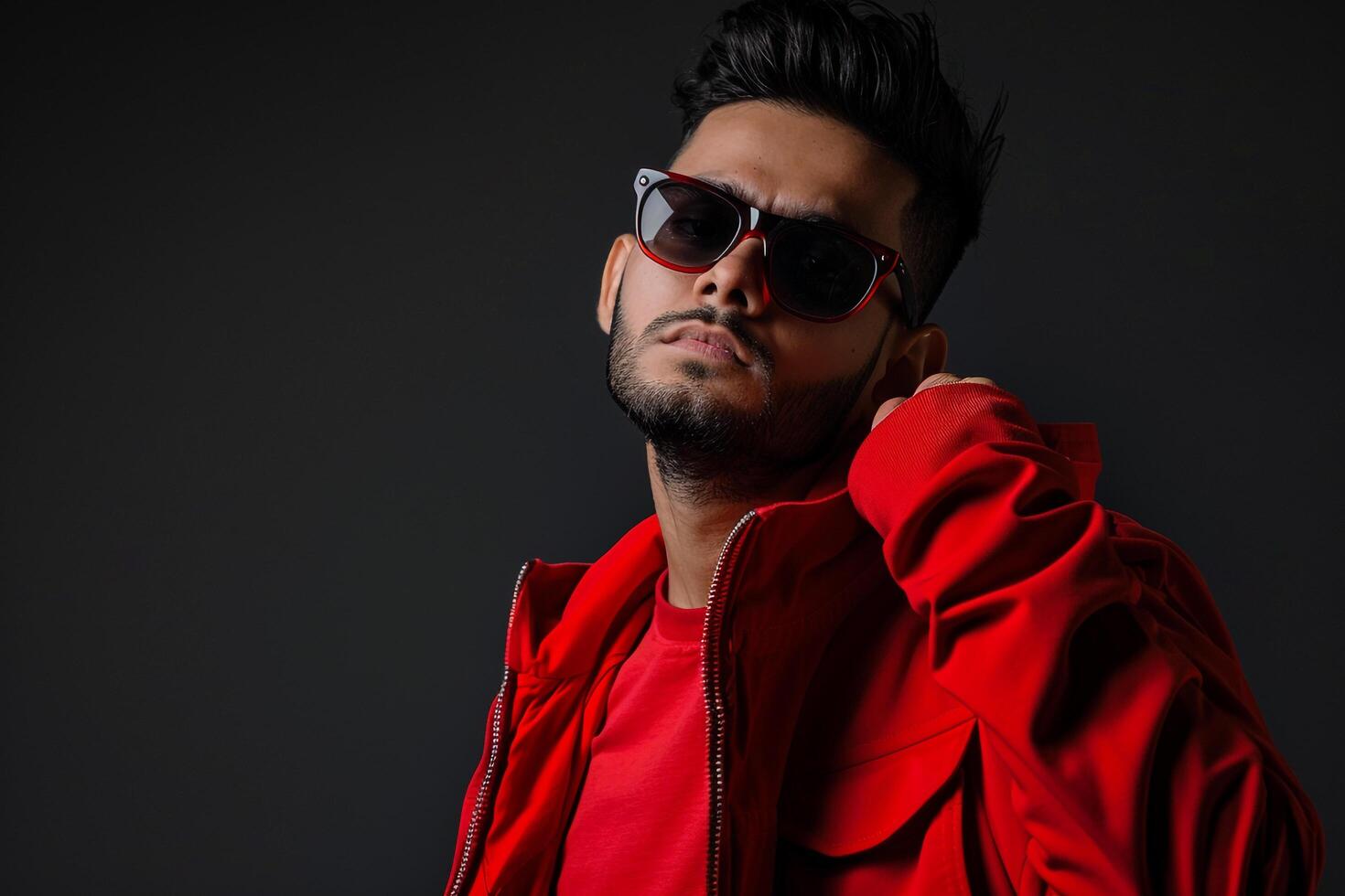 Red pullover and Sunglasses on Male with Charcoal Background  Fashion Lifestyle portrait Featuring Bold Style photo