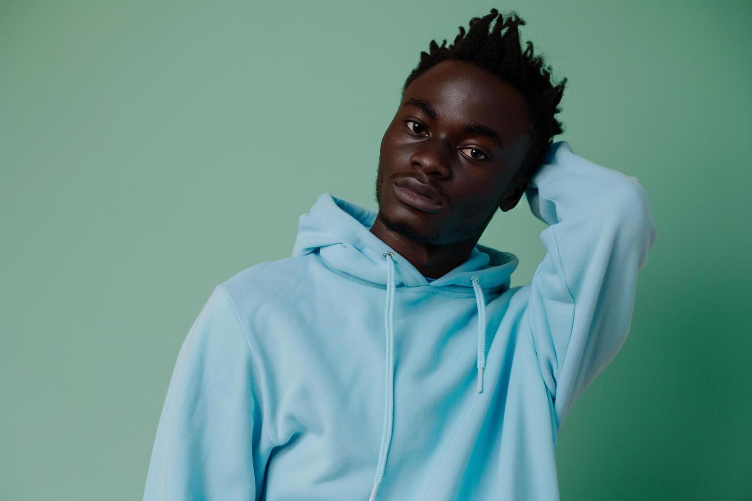 Hoodie Clad Male Fashion portrait with Mint Green Background Highlighting a Trendy and Stylish Fashion StateMalet photo