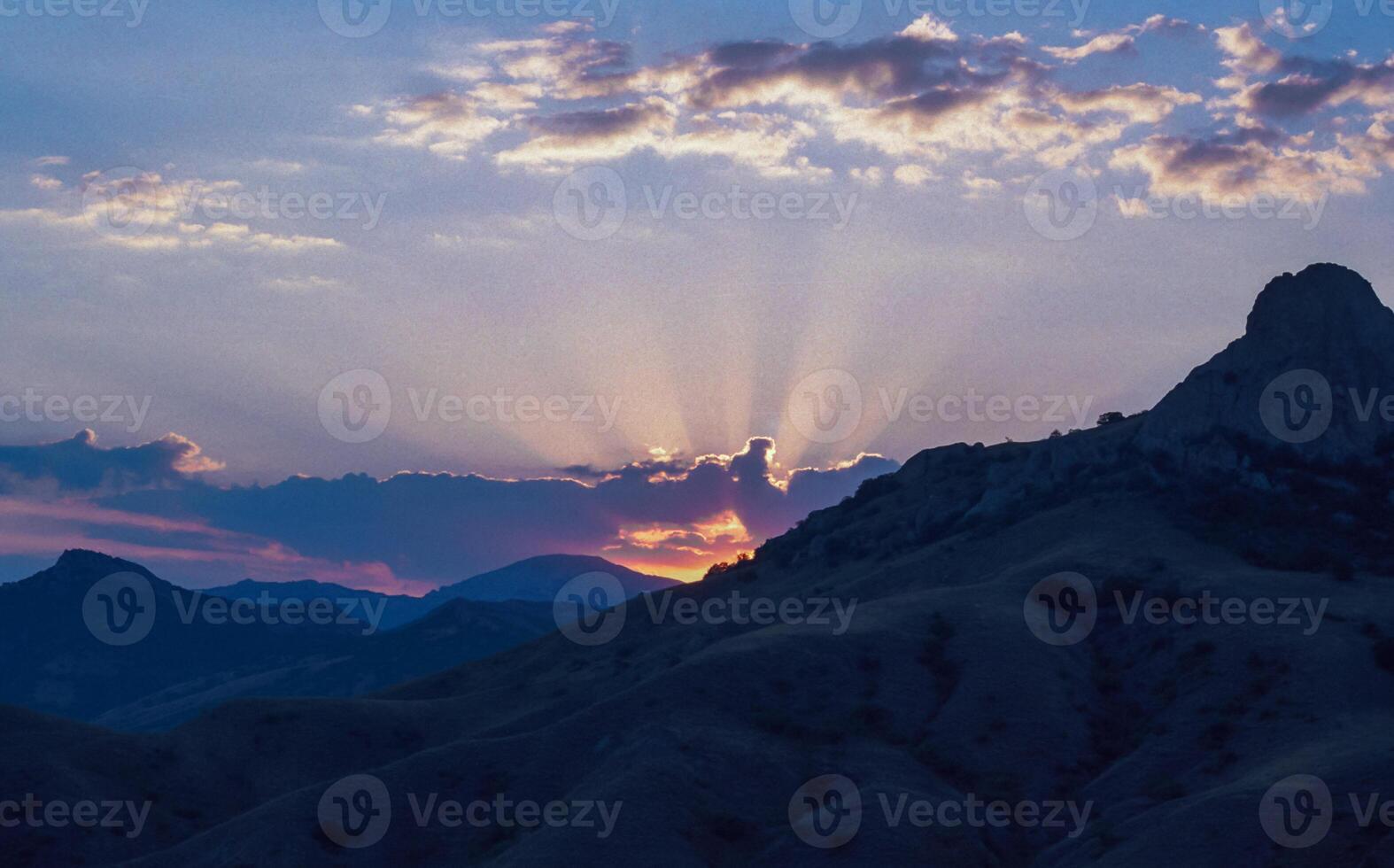 Sun rays in the clouds at sunset in the mountains of Karadag, Crimea photo