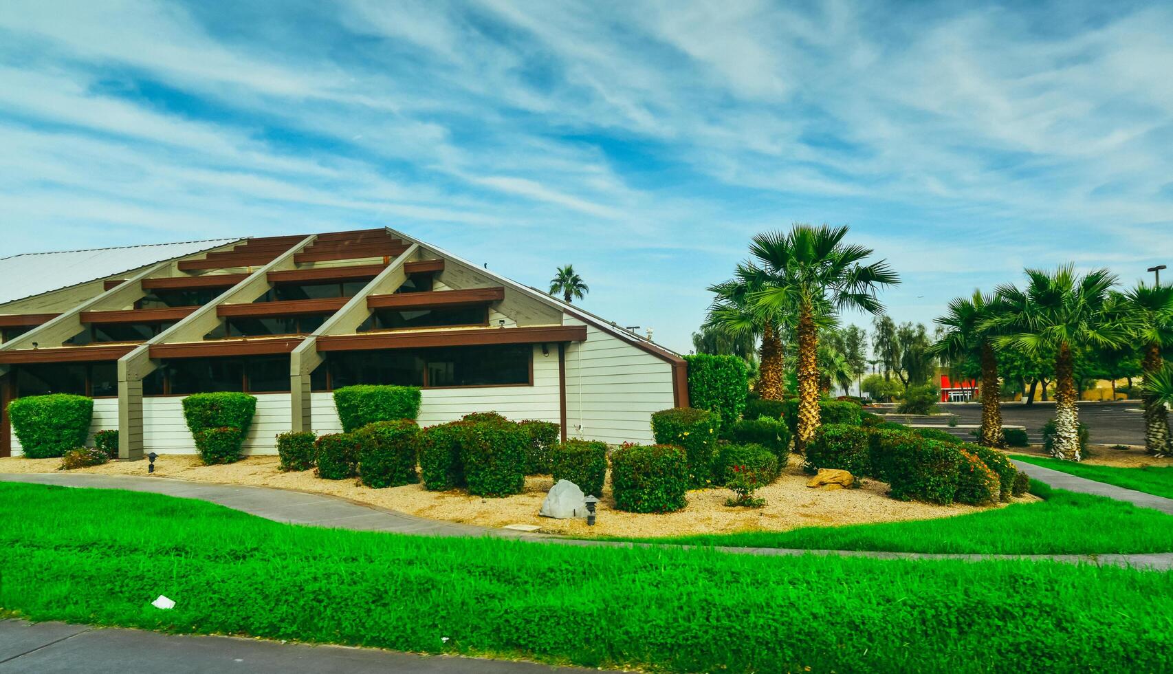 ARIZONA, USA - NOVEMBER 25, 2019 landscape design, trimmed green bushes near a house with palm trees, Arizona photo