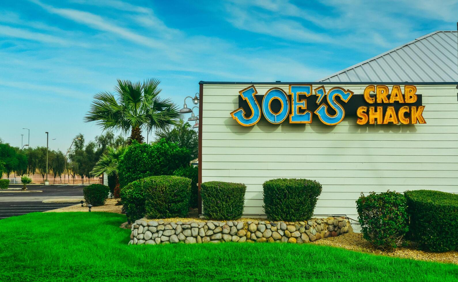 ARIZONA, USA - NOVEMBER 25, 2019 JOES Crab Shach, landscape design, trimmed green bushes near a house with palm trees, Arizona photo