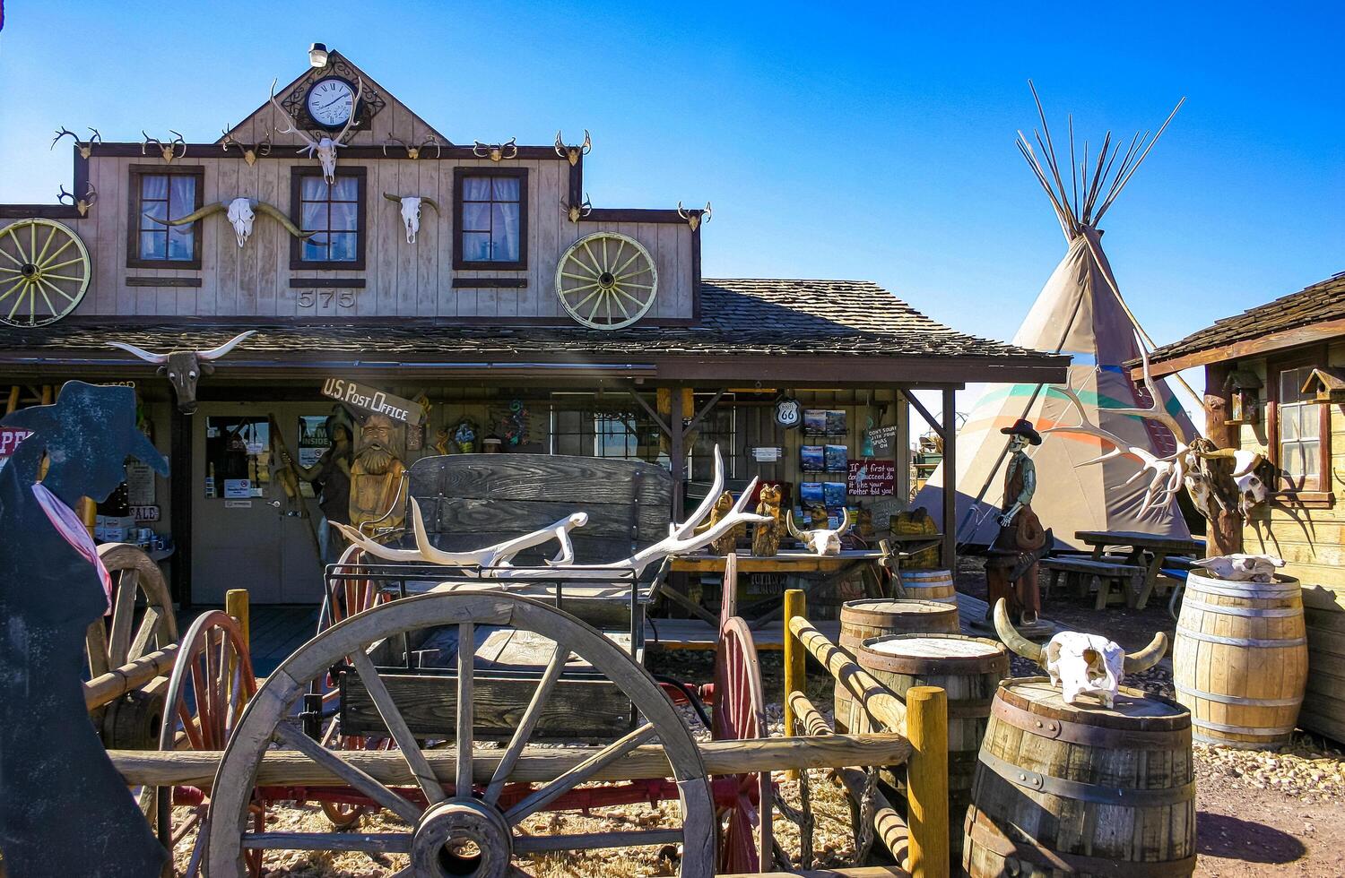 Arizona, USA - November 27, 2009 Rustic wooden saloon flanked by a traditional teepee and vintage barrels in a western setting photo