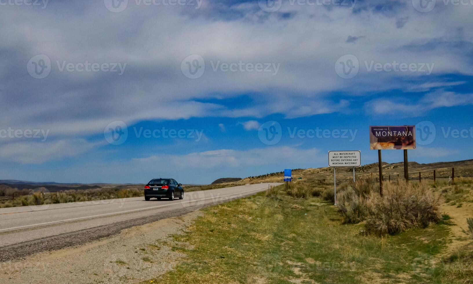 The landscape is in the wild. A road going into the distance, white clouds on the horizon. photo