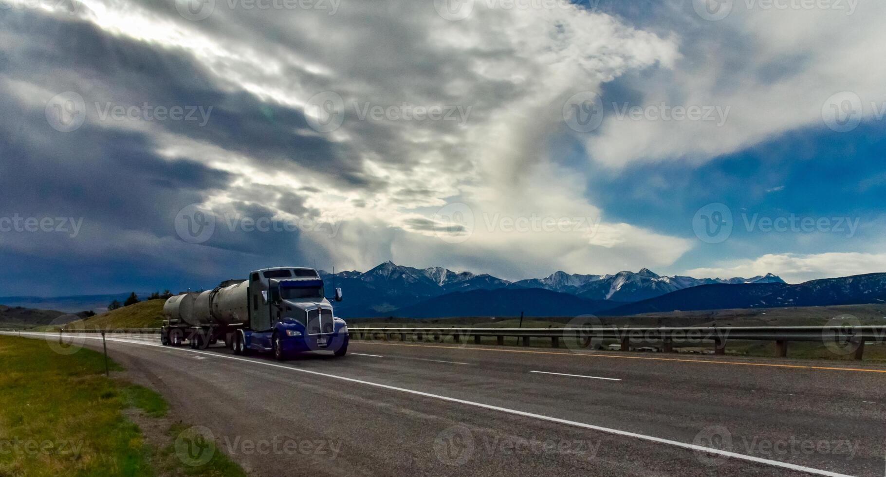 Car on an asphalt road against the sky, white clouds on the horizon photo