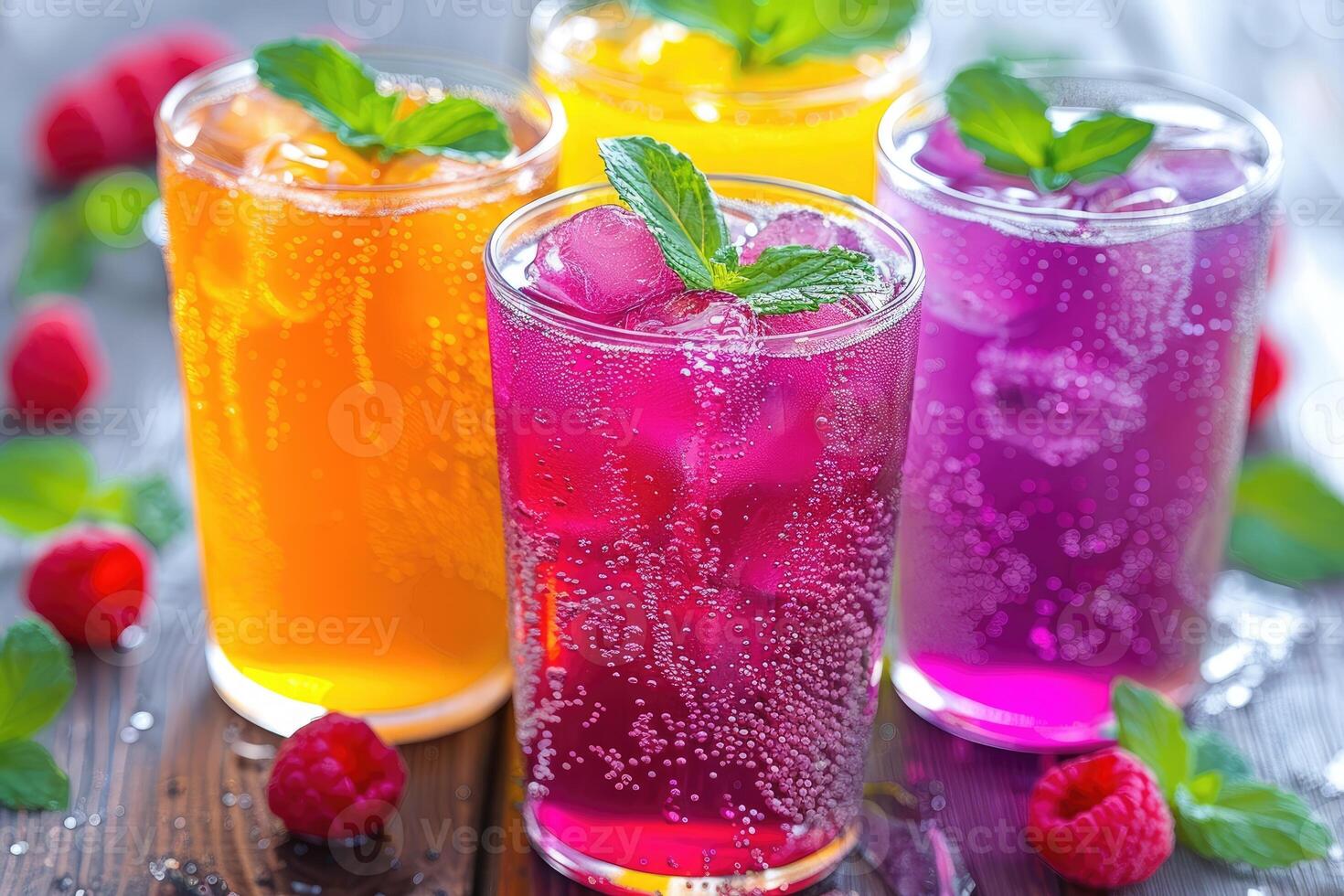 Three Glasses of Colorful Fizzy Drinks with Raspberries and Mint photo