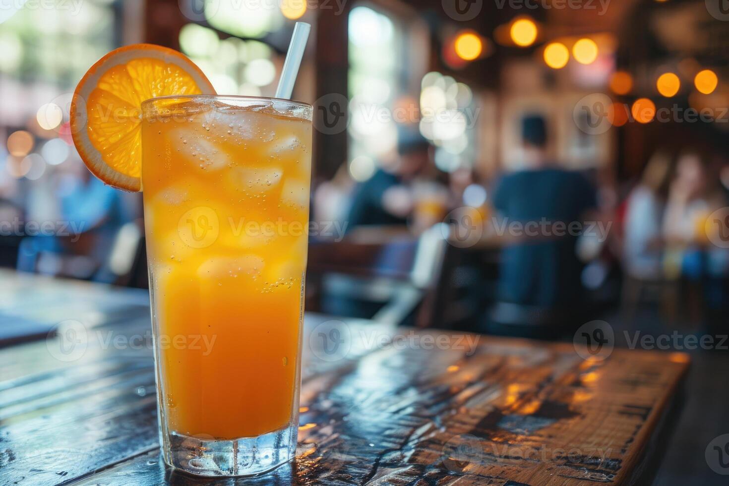 Iced Orange Drink in a Glass with a Straw on a Wooden Table photo