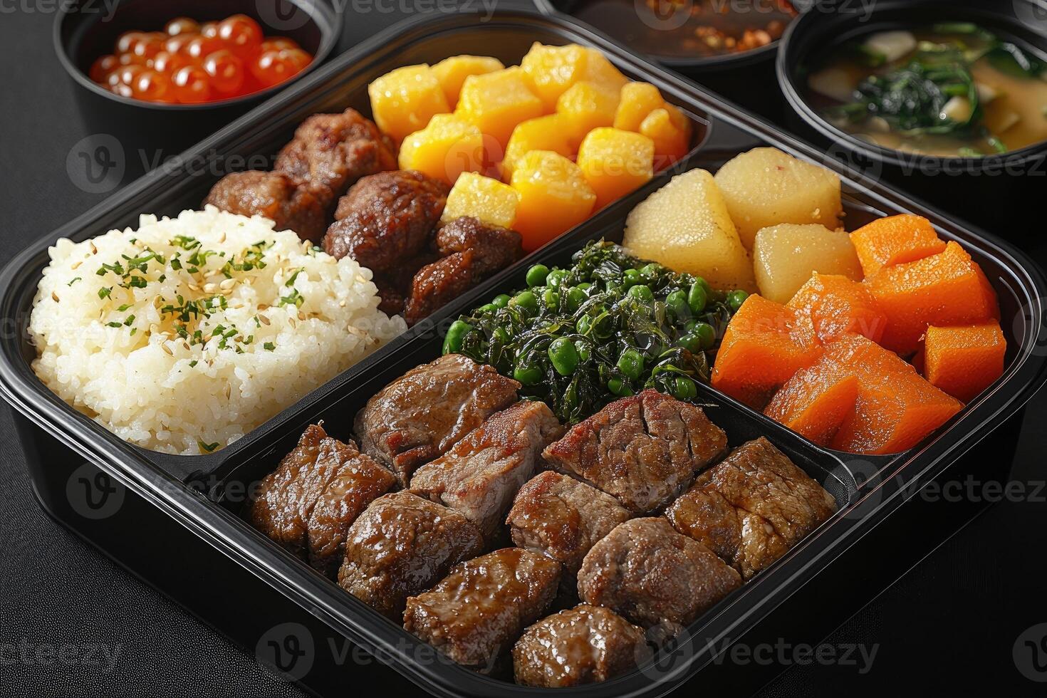 Japanese Bento Box with Beef, Rice, Vegetables, and Soup photo