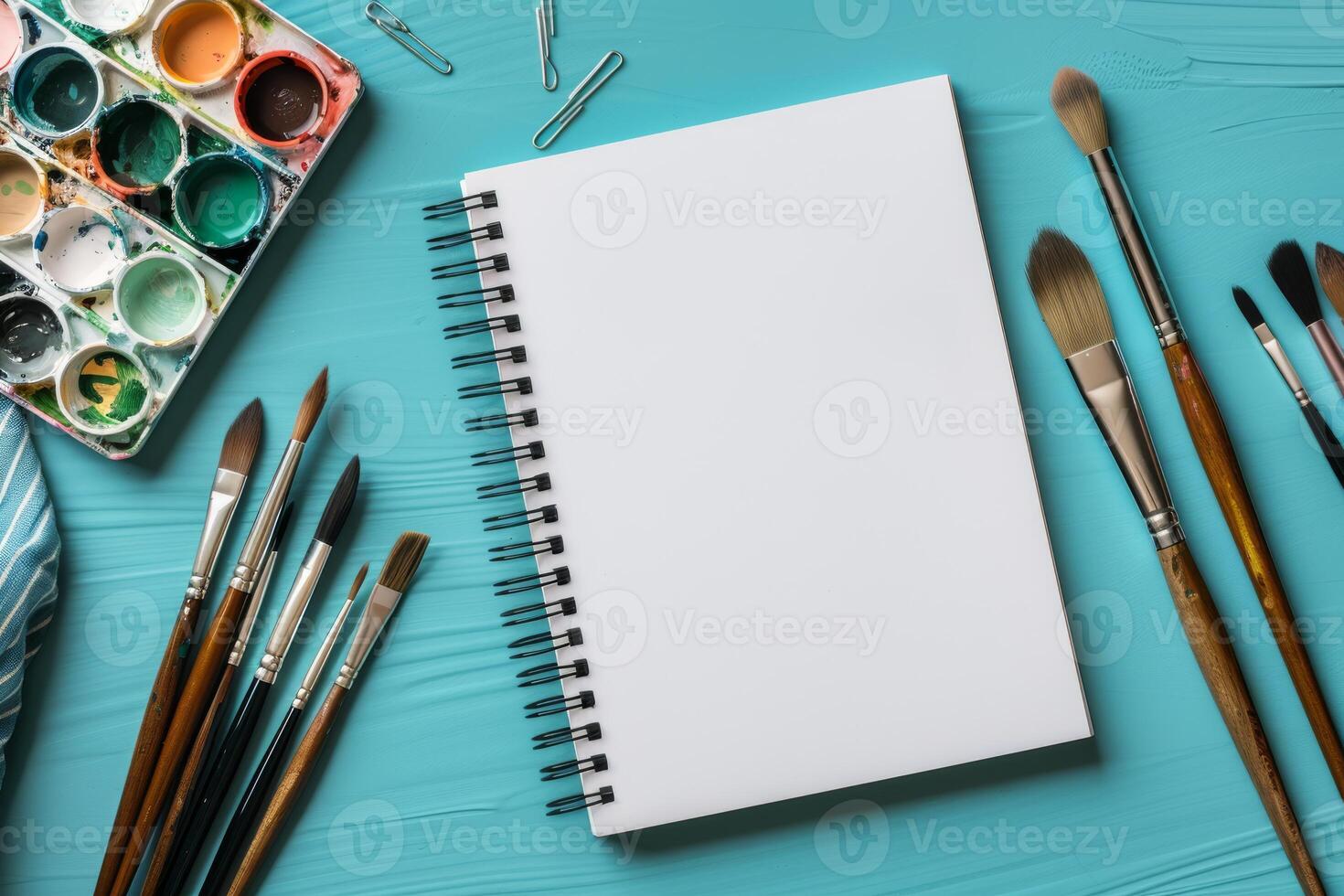 This mockup features a sketchbook, paintbrushes, and a colorful watercolor palette, ideal for artists seeking inspiration and essential tools to express their unique creative vision photo