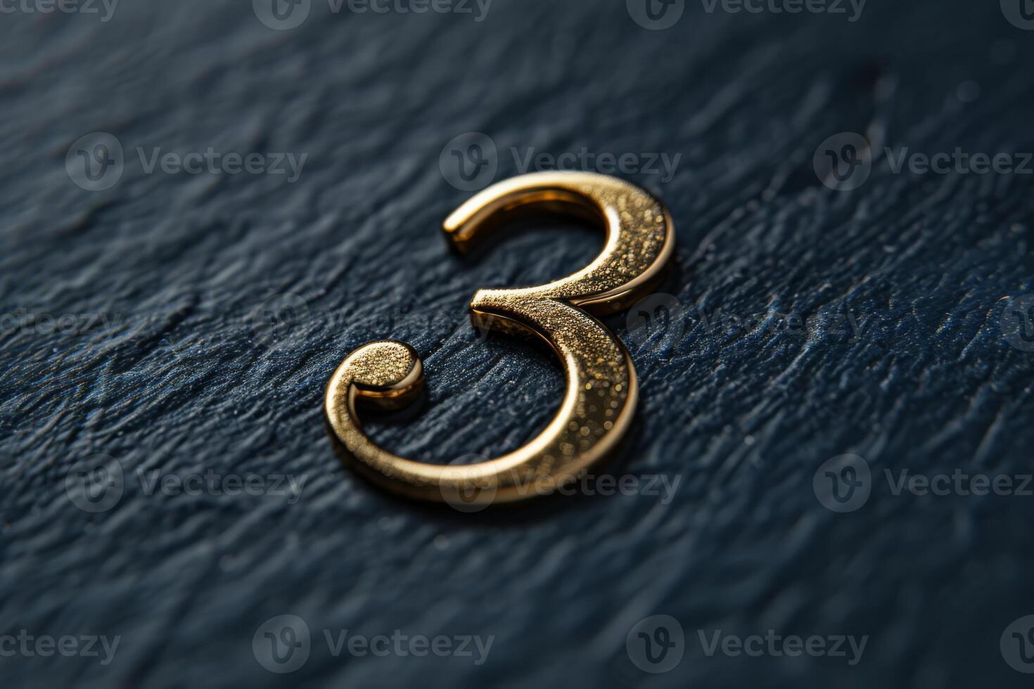 A stylish golden number 3 is displayed prominently on a dark, textured surface, perfect for various media projects photo