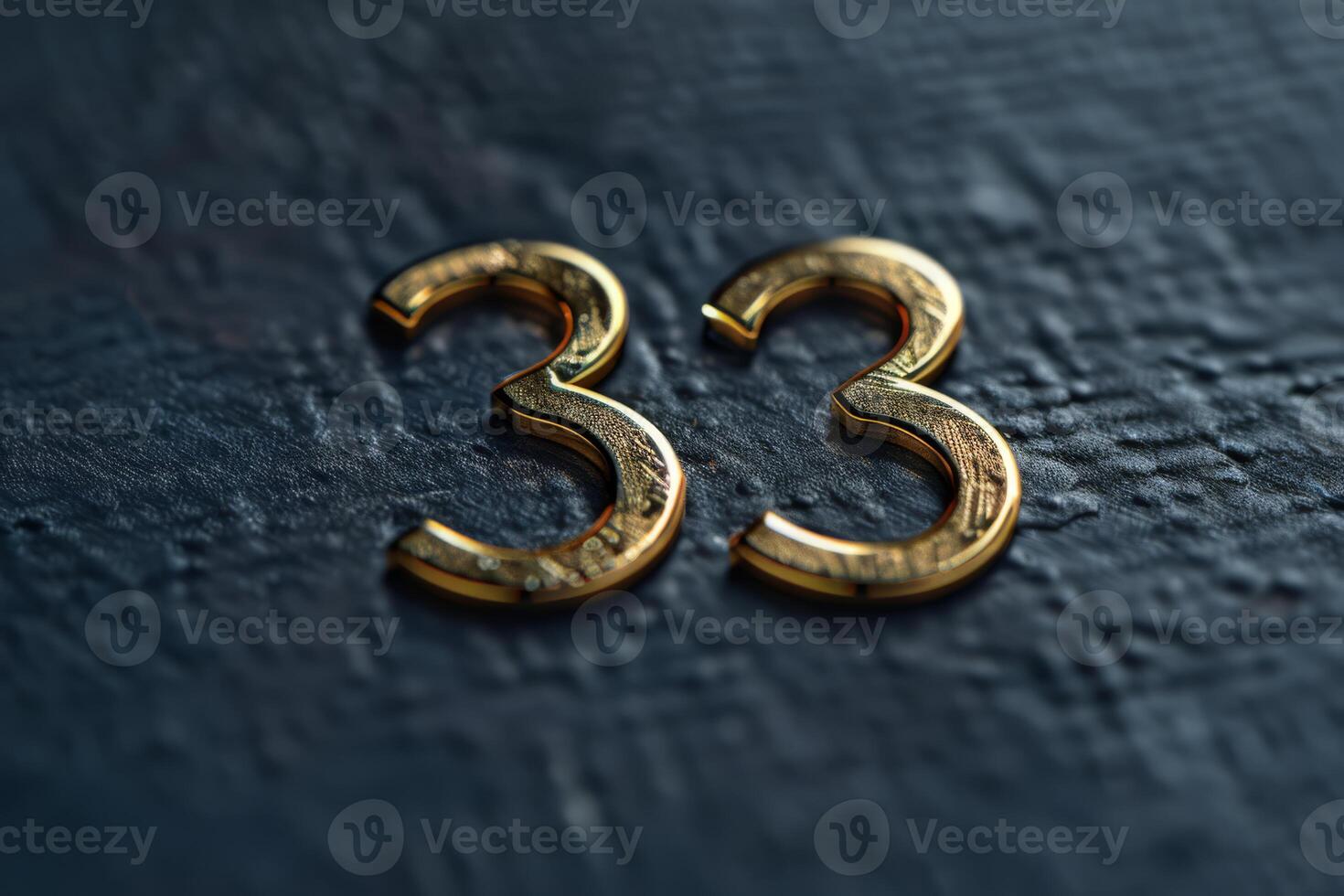 A stylish and elegant golden number 33 is prominently displayed on a textured and rich black surface photo