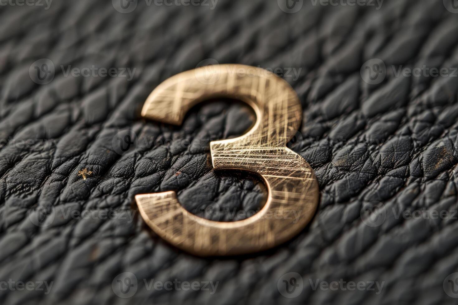 This is a beautifully detailed closeup view of a striking bronze number 3 displayed on a textured black surface photo