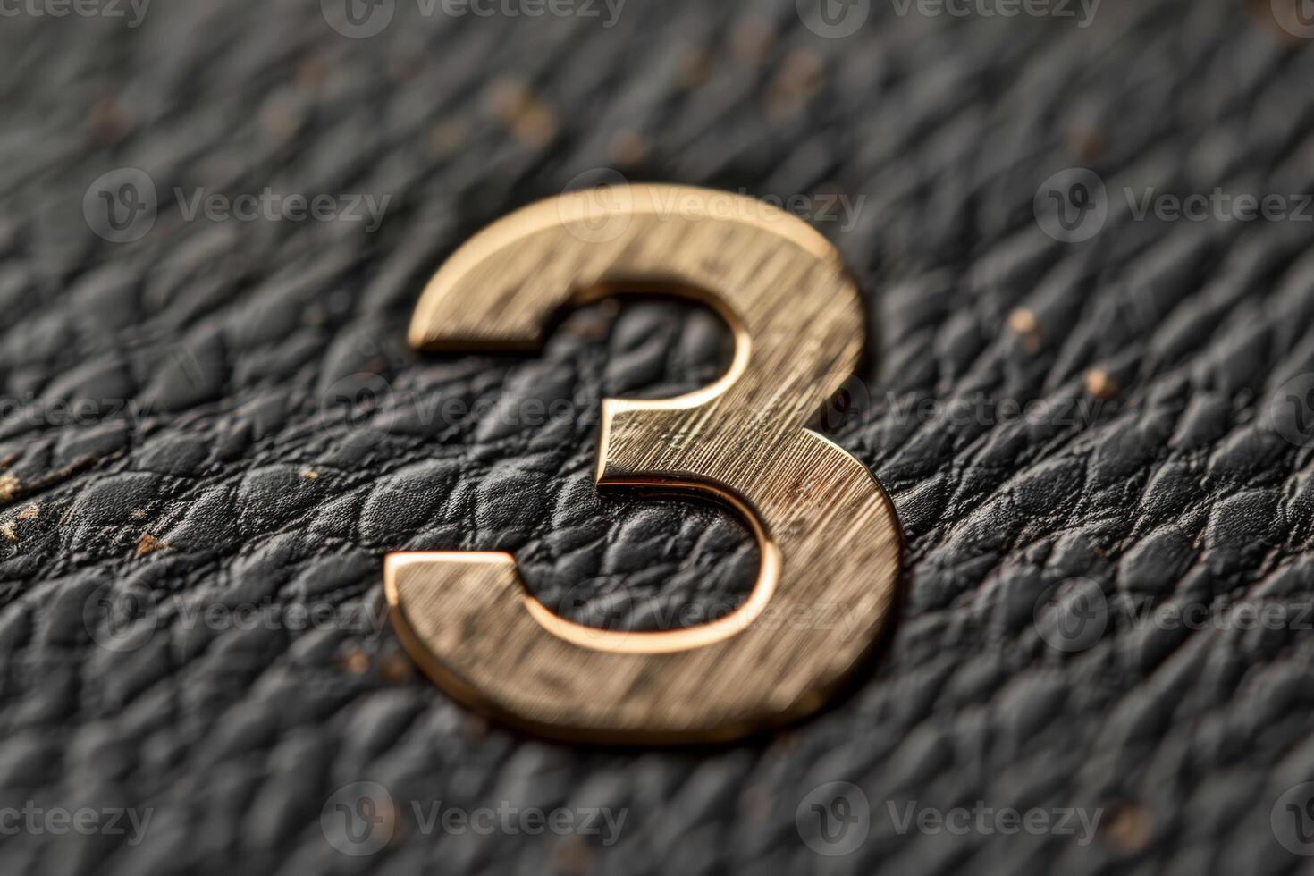 Closeup of a bronze number 3 on deep black leather, ideal for decorative applications or design purposes photo