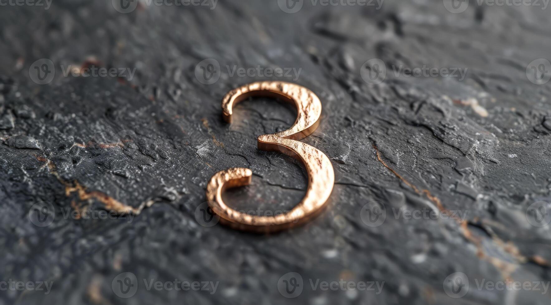 A stylish gold numeral 3 displayed on a textured slate surface that is perfect for enhancing modern decor photo