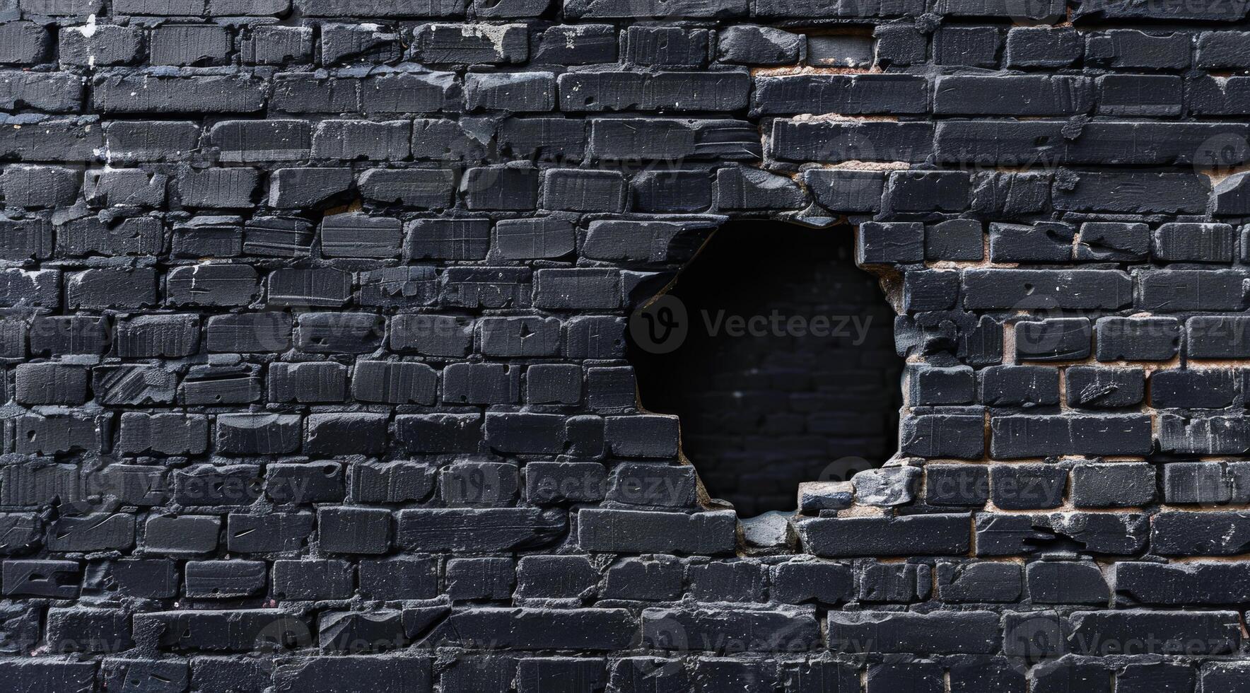 This image shows a closeup of a textured black brick wall with a prominent circular hole, highlighting the contrast between the dark bricks and the exposed area behind, adding depth and intrigue photo