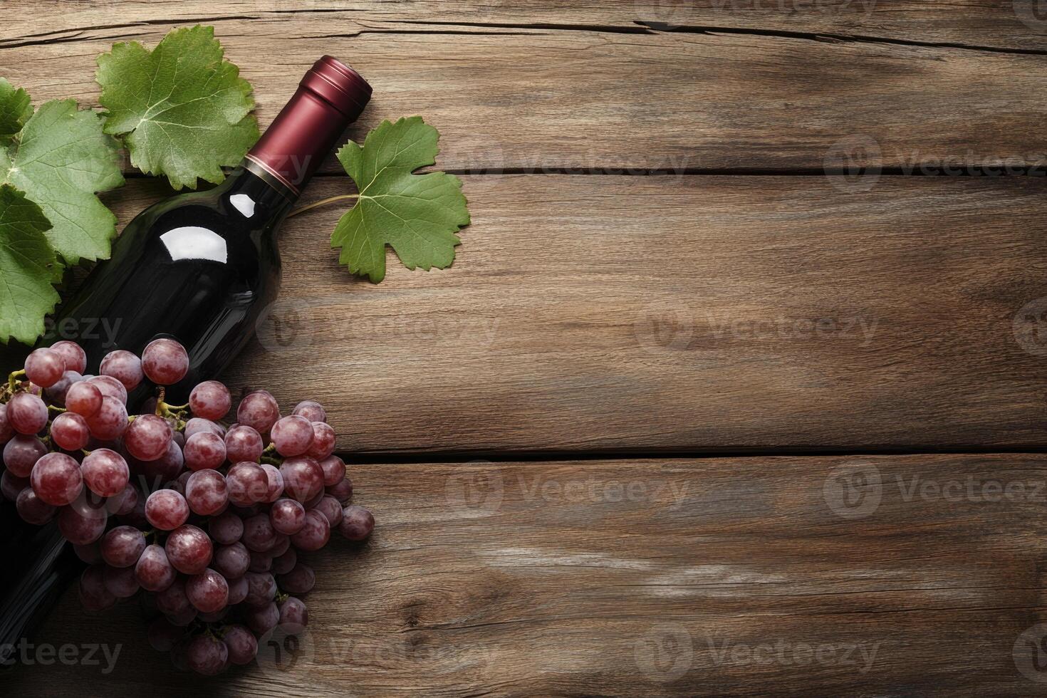 A wine bottle and grapes on a wooden table with a blank area. photo