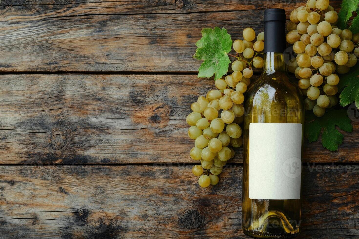 A wine bottle and grapes on a wooden table with a blank area. photo