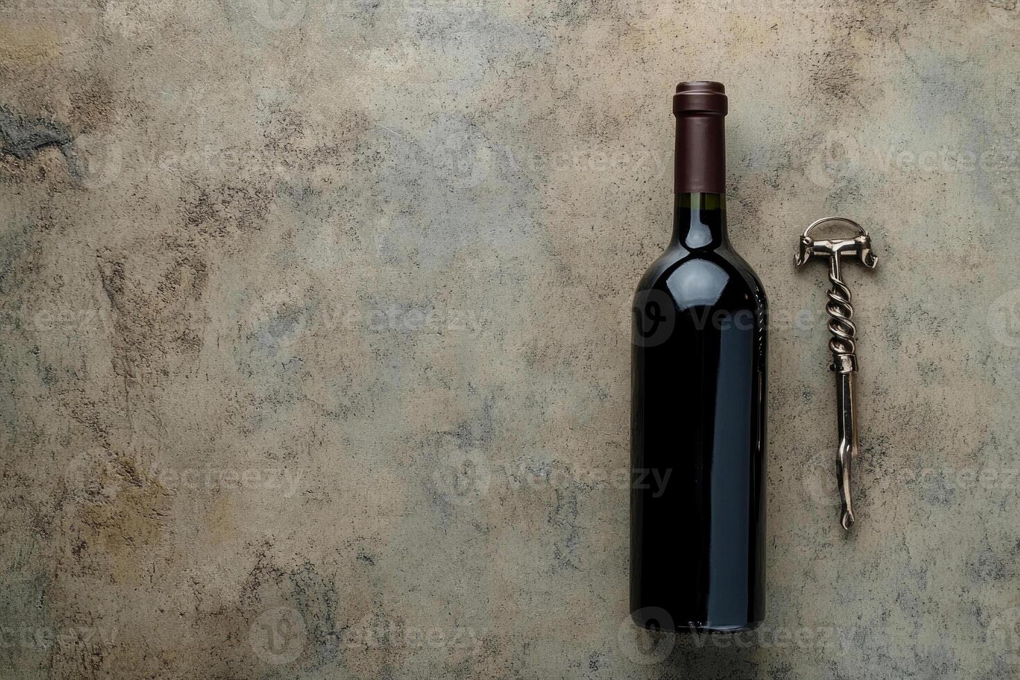 Wine bottle and corkscrew on a textured background with blank space. photo