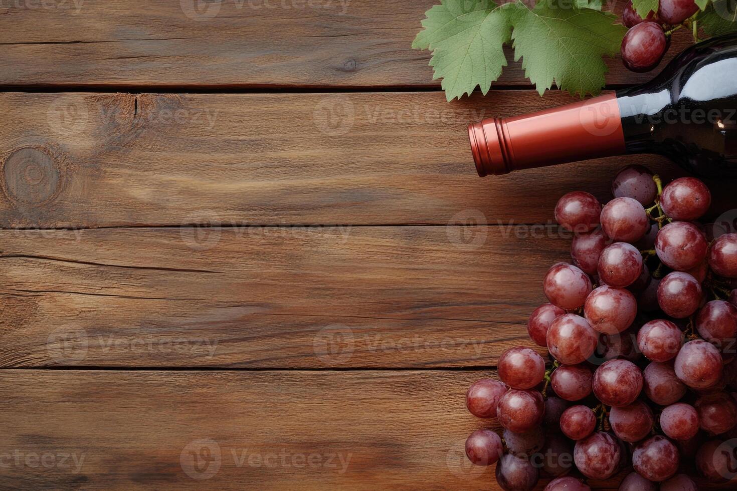 A wine bottle and grapes on a wooden table with a blank area. photo