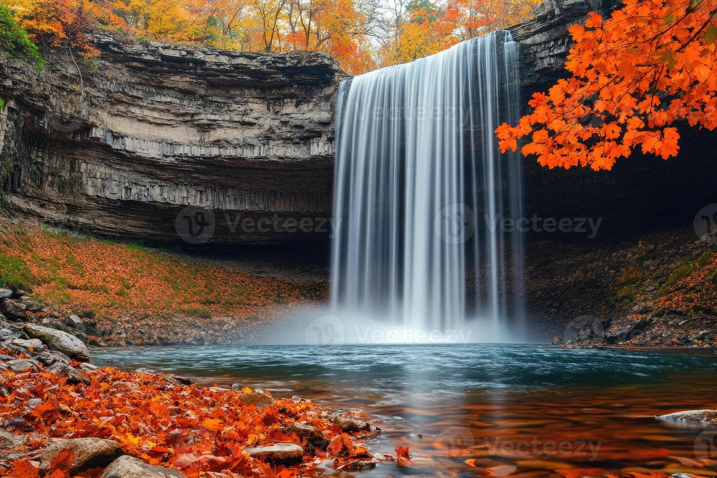 A stunning waterfall framed by autumn foliage. photo