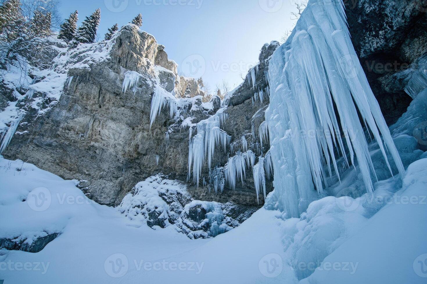 A frozen waterfall in a snow-covered landscape. photo