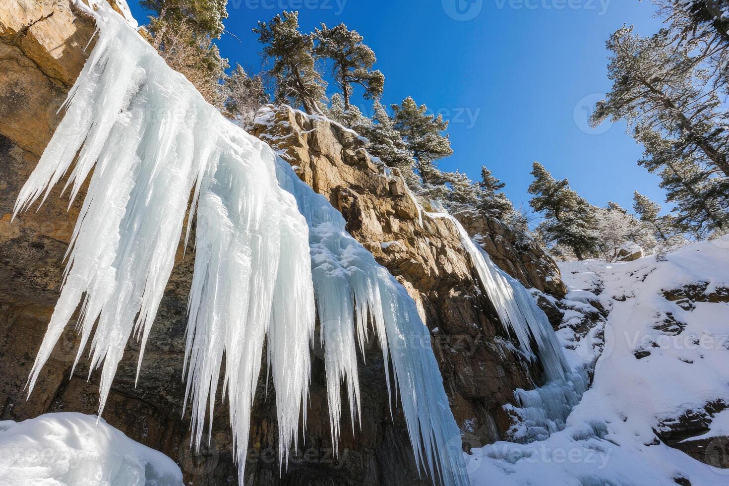 A frozen waterfall in a snow-covered landscape. photo