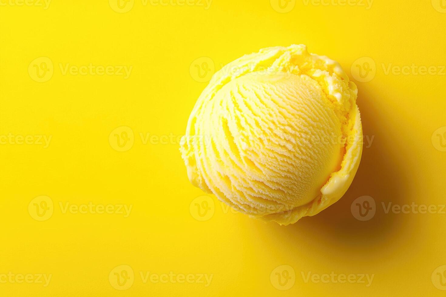 A top-down view of a yellow ice cream scoop on a matching yellow background. photo