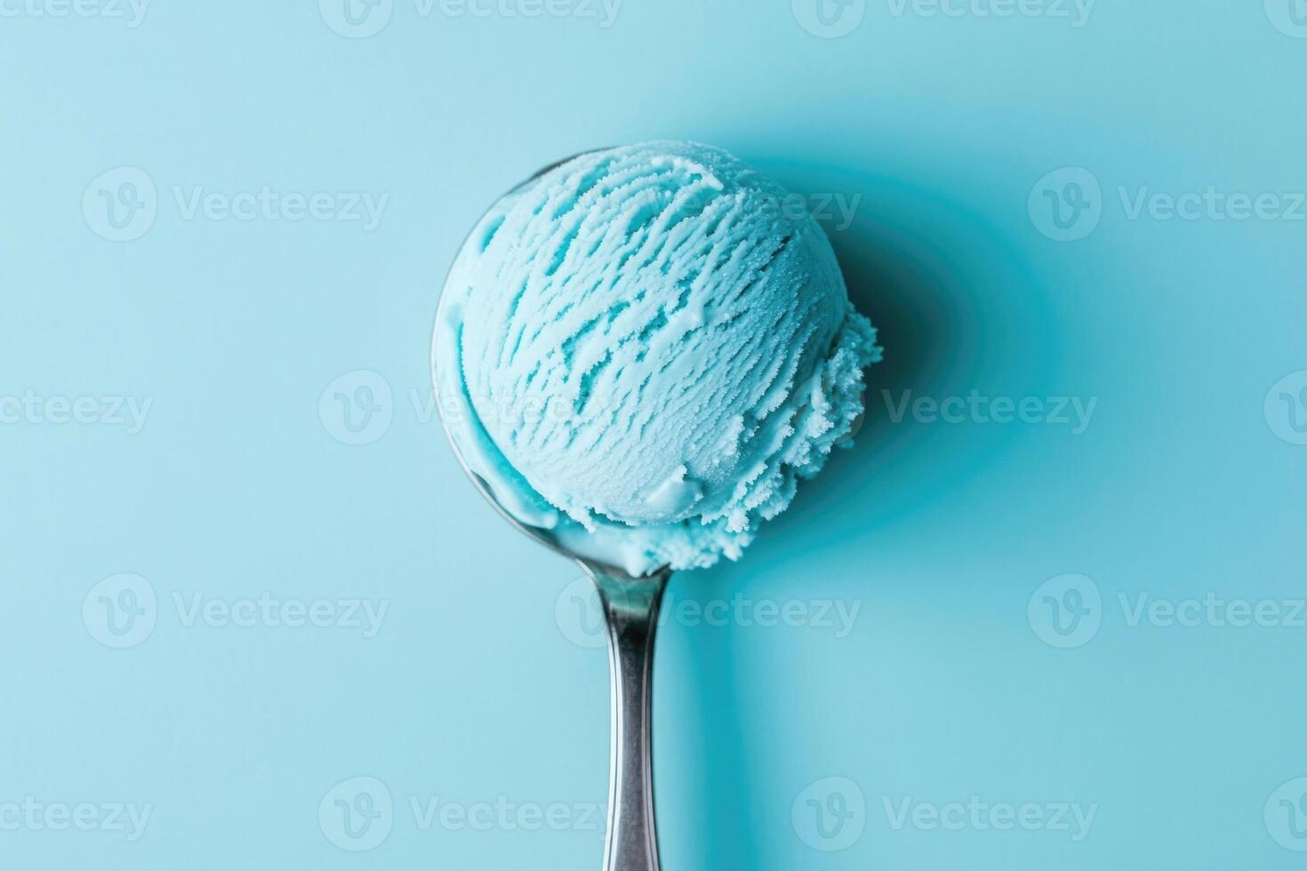 A top-down view of a light blue ice cream scoop on a light blue background. photo