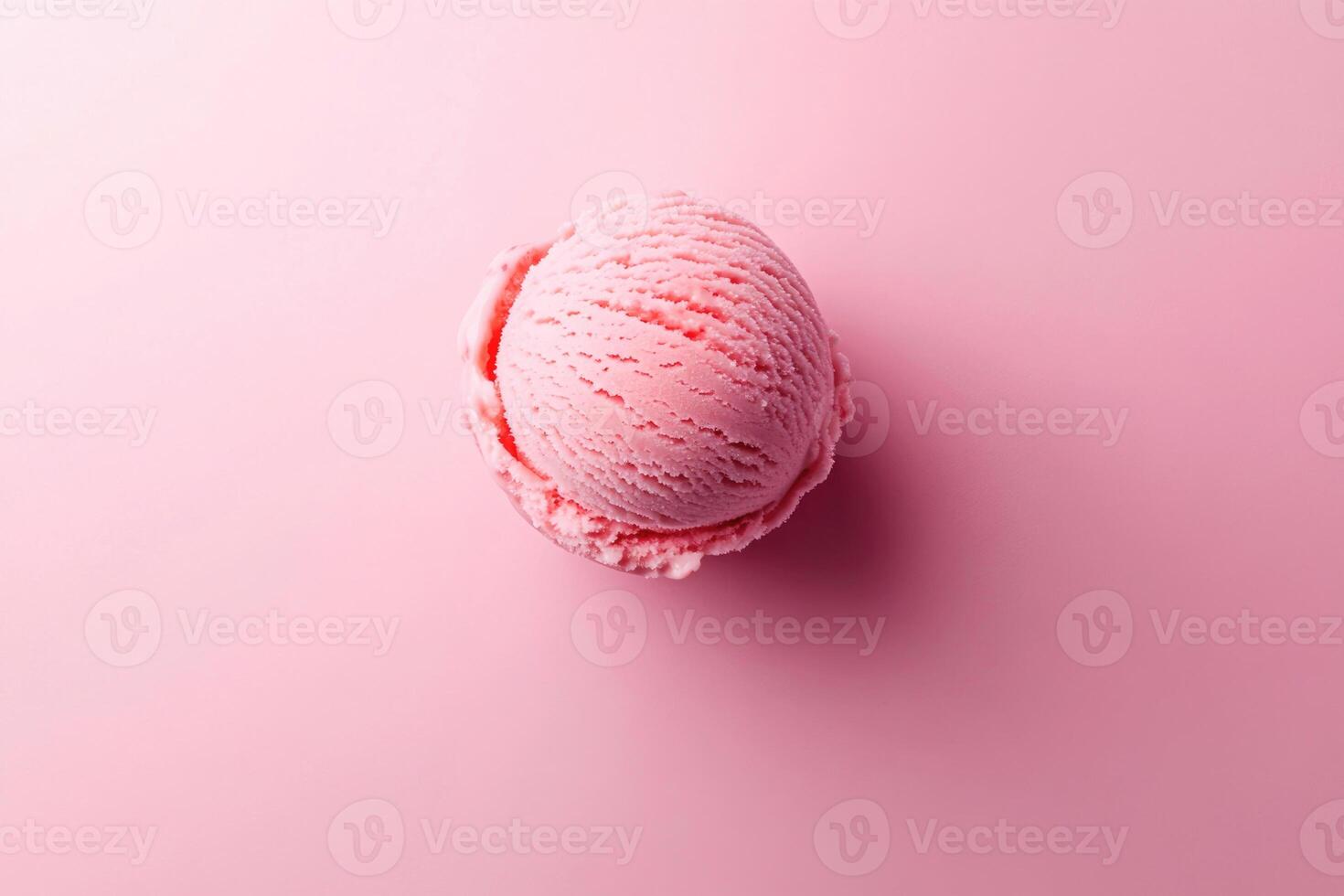 A top-down view of a pink ice cream scoop on a matching pink background. photo