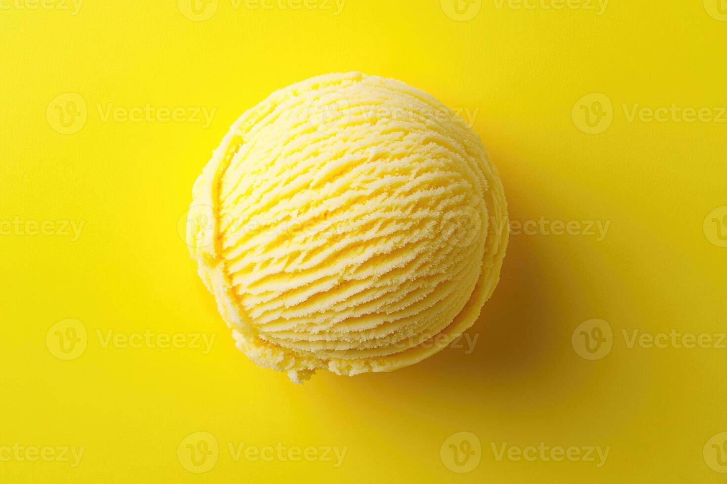 A top-down view of a yellow ice cream scoop on a matching yellow background. photo