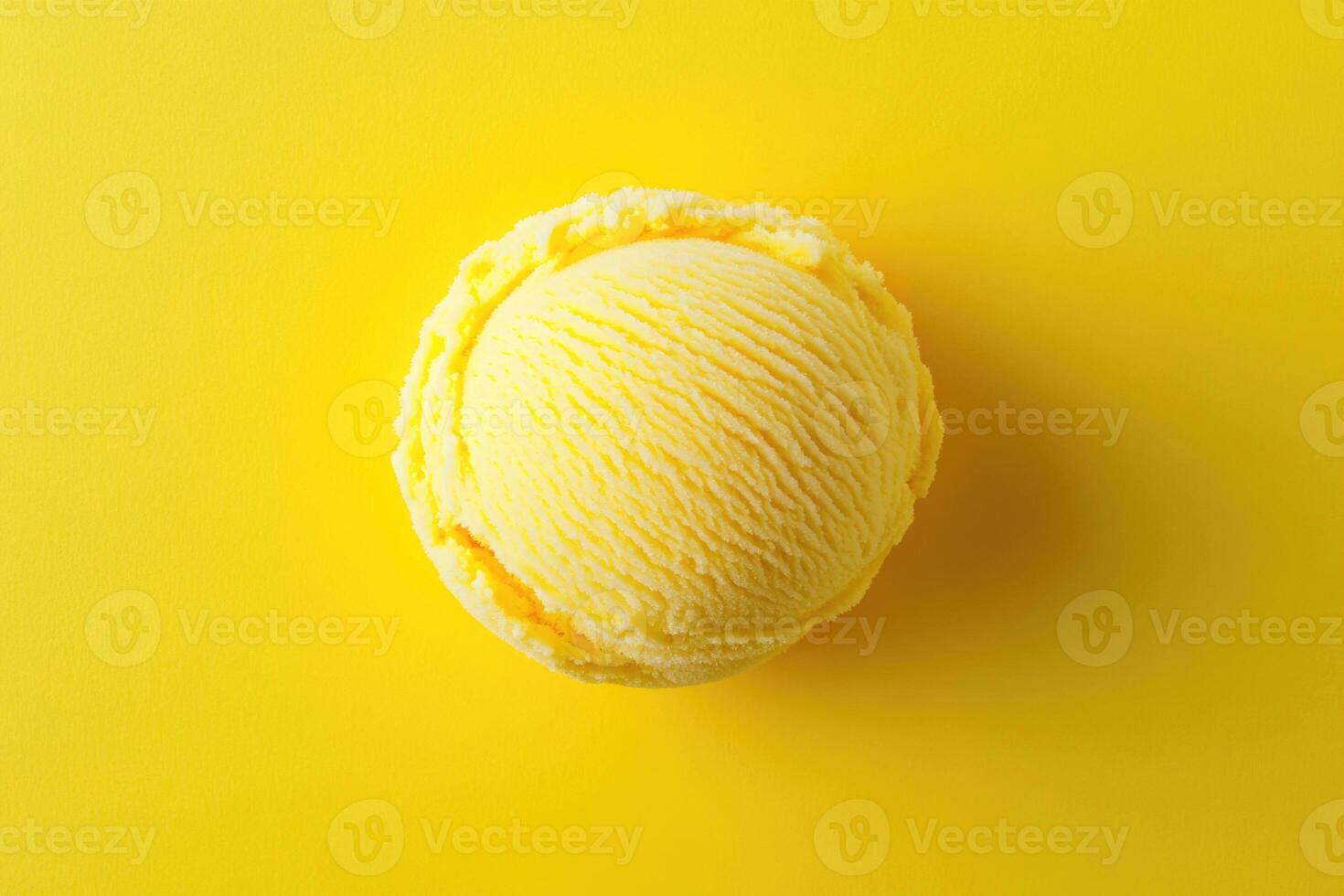 A top-down view of a yellow ice cream scoop on a matching yellow background. photo