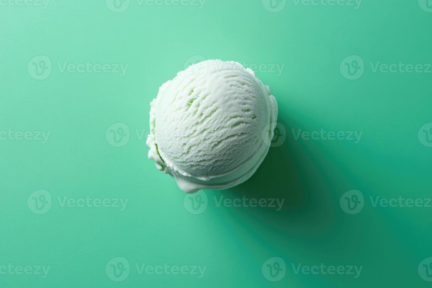 A top-down view of a mint green ice cream scoop on a mint green background. photo
