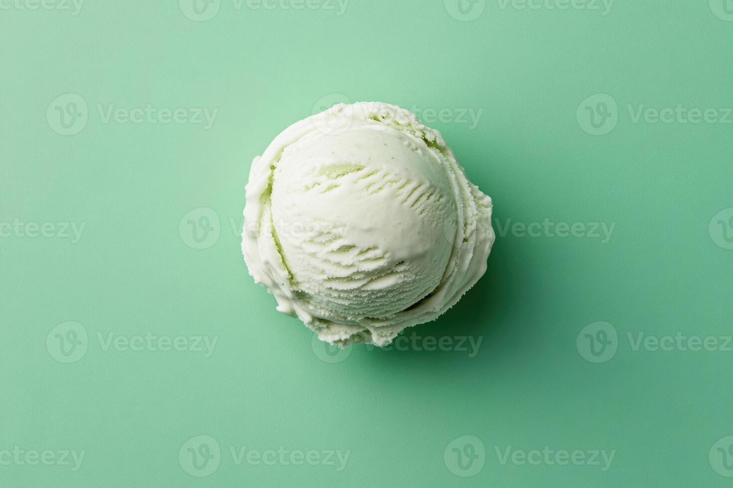 A top-down view of a mint green ice cream scoop on a mint green background. photo
