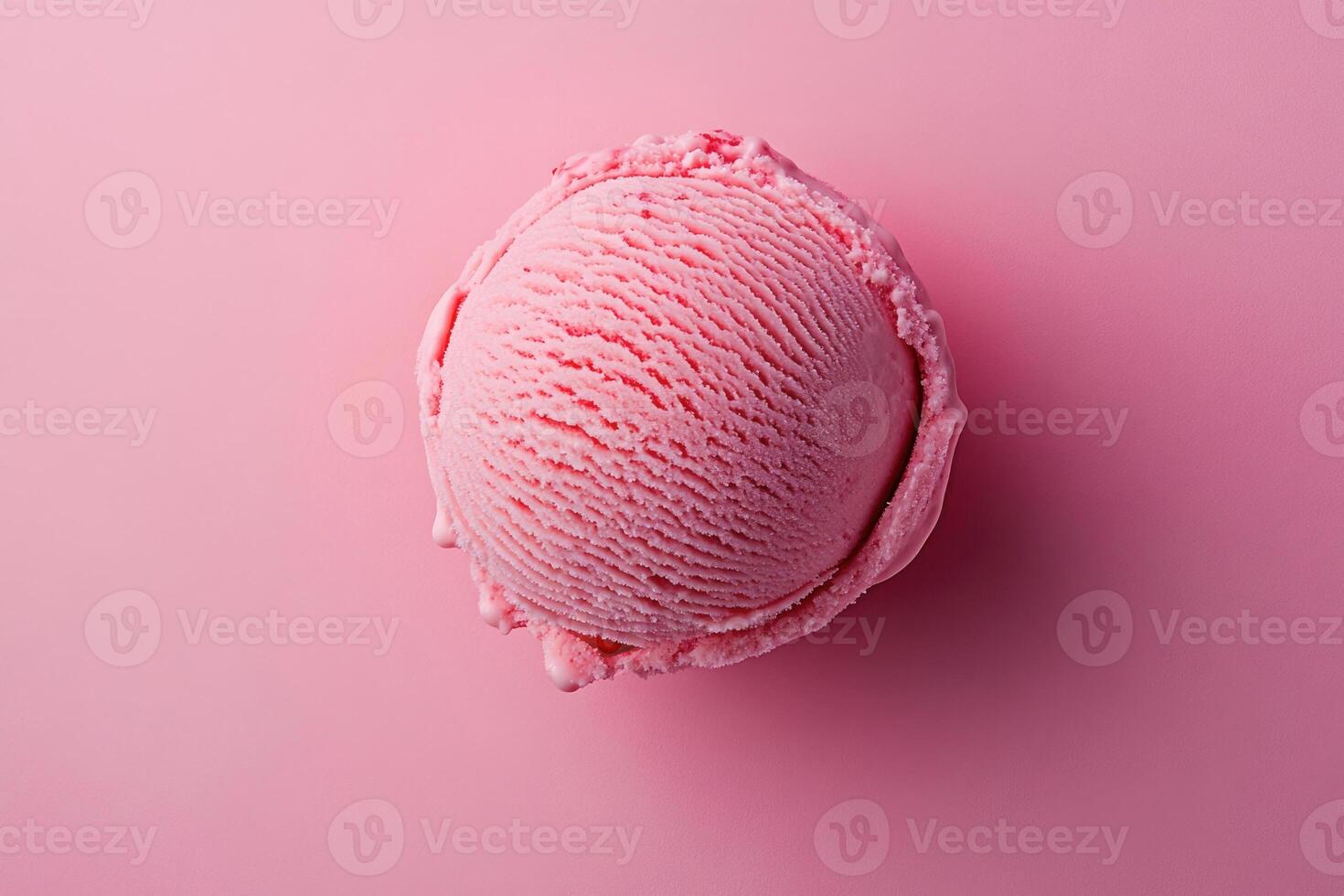 A top-down view of a pink ice cream scoop on a matching pink background. photo
