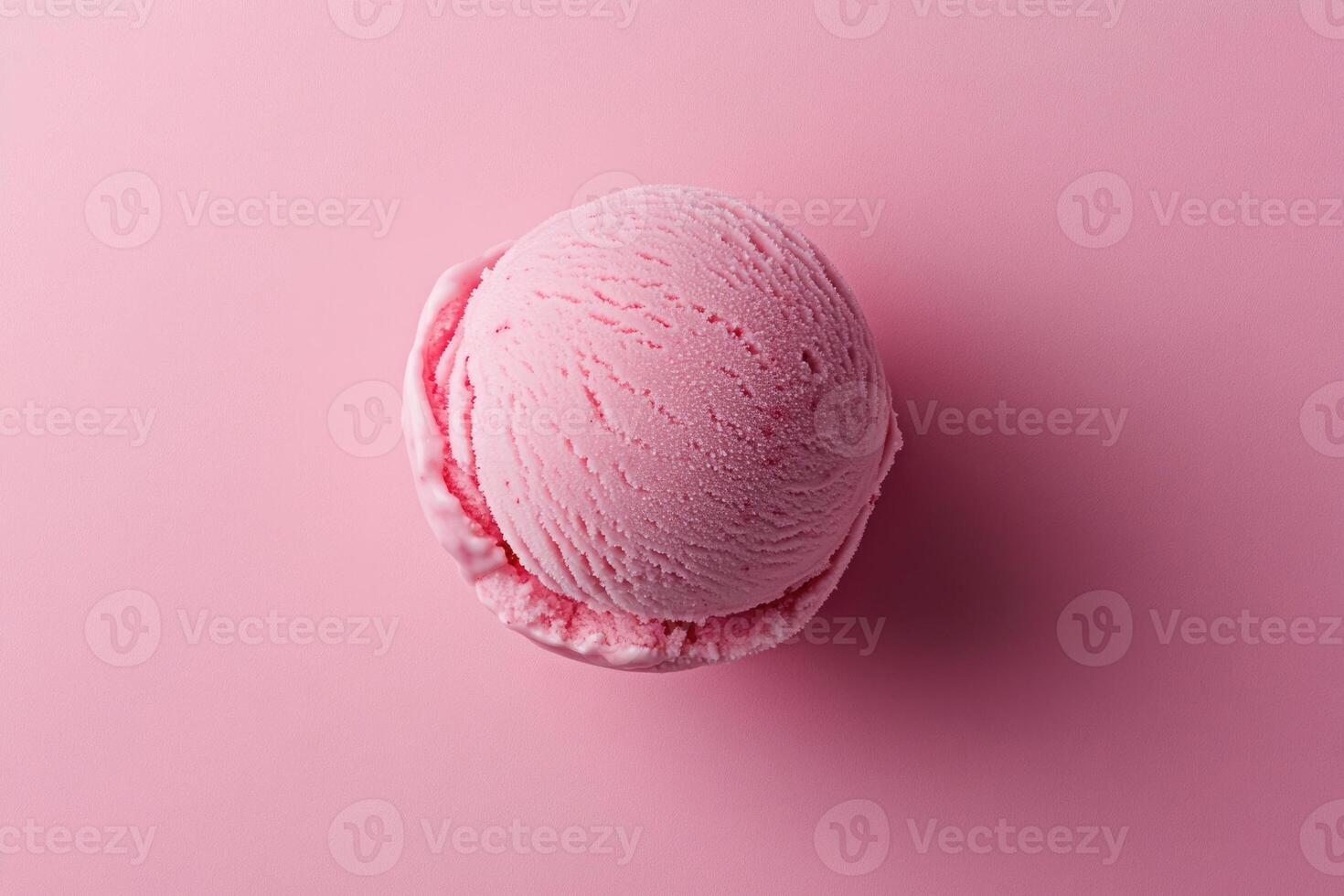 A top-down view of a pink ice cream scoop on a matching pink background. photo