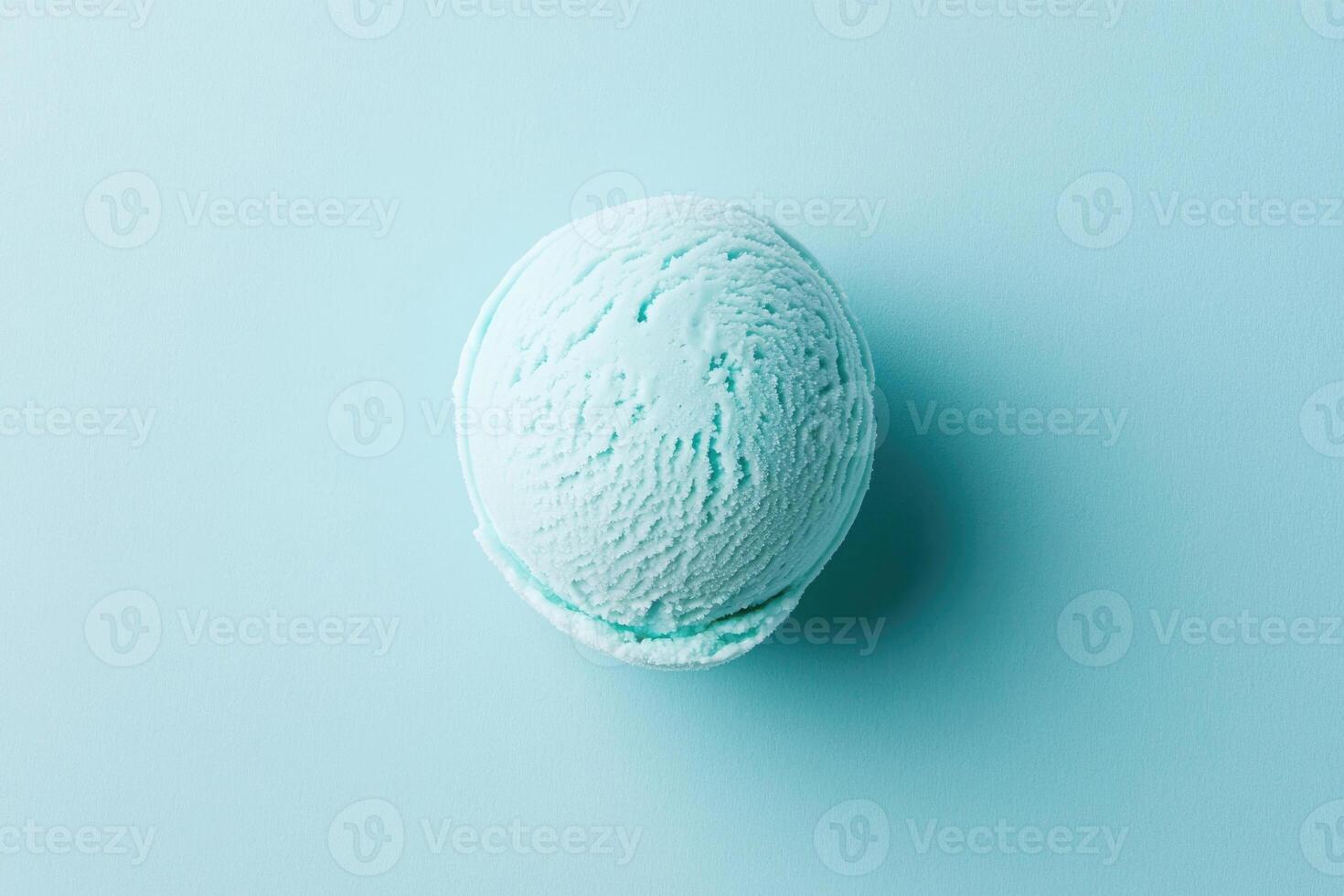 A top-down view of a light blue ice cream scoop on a light blue background. photo