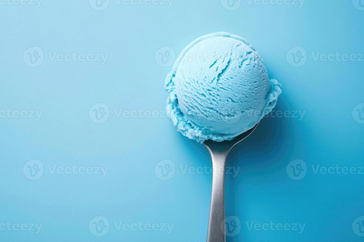 A top-down view of a light blue ice cream scoop on a light blue background. photo