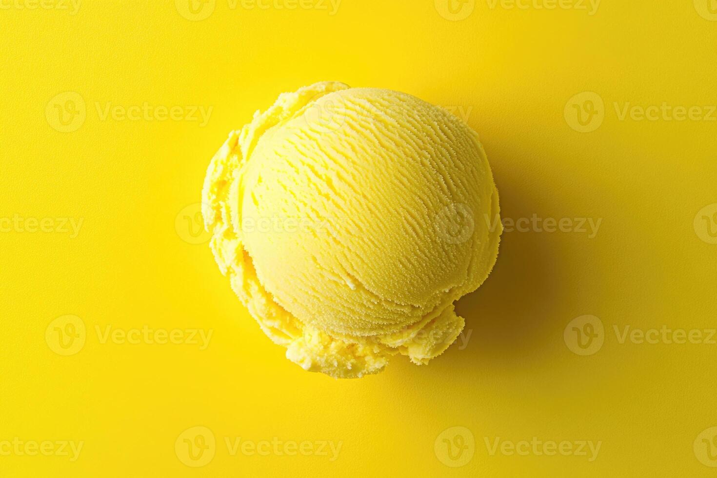 A top-down view of a yellow ice cream scoop on a matching yellow background. photo