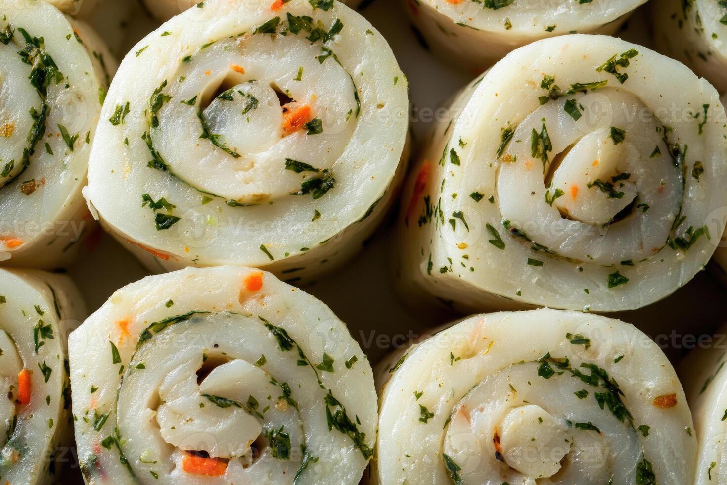 A savory selection of fish roulade slices creates a delicate, textured background. photo