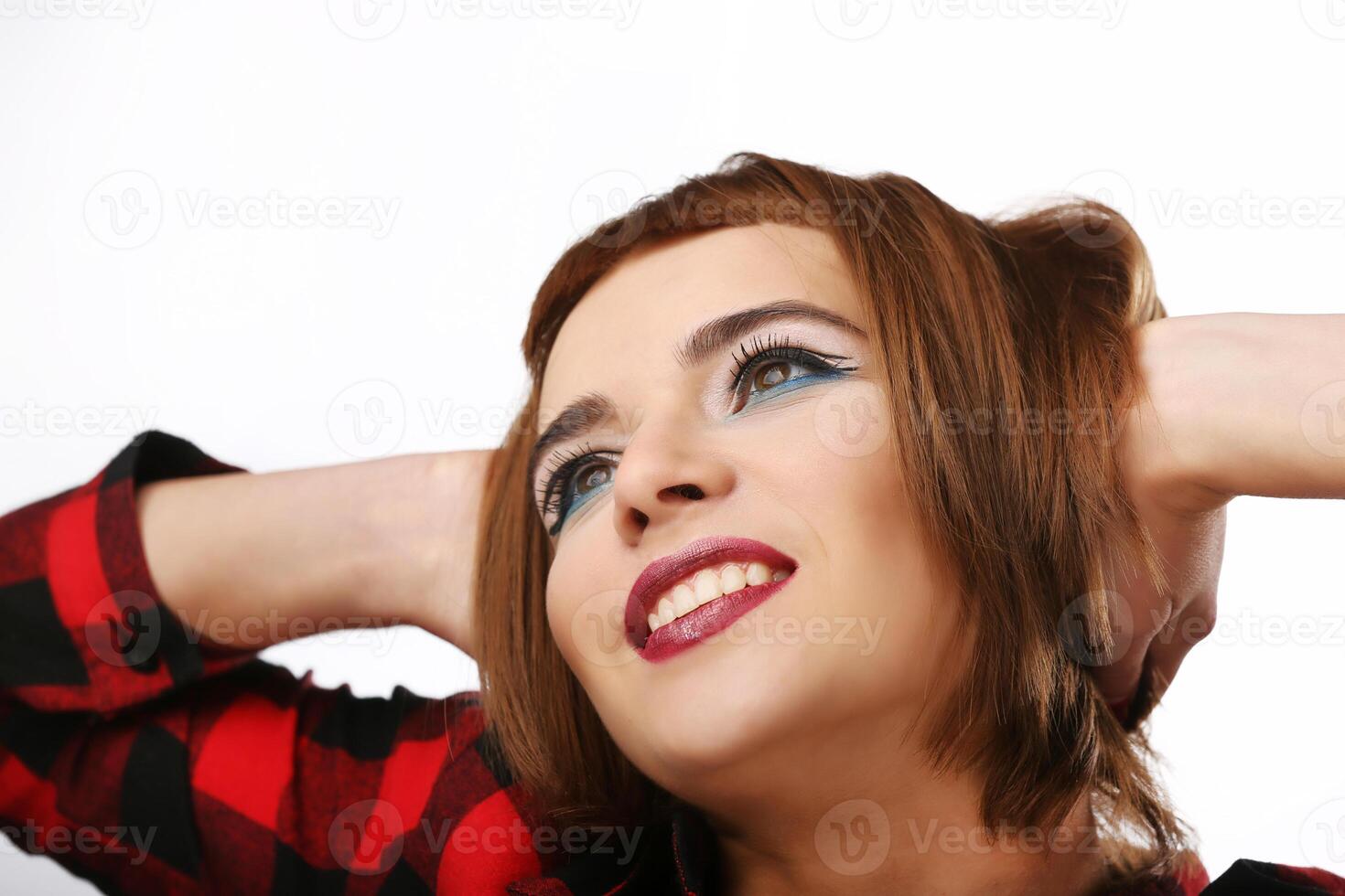 Isolated portrait of a smiling young woman. Red-haired girl. Looking aside. photo