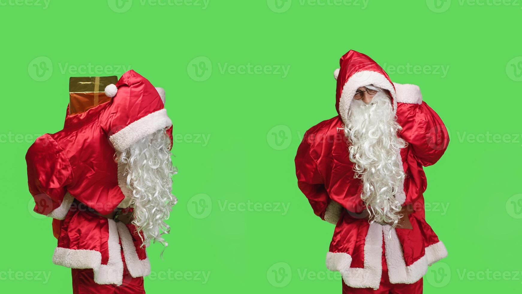 Ill man in festive suit having back pain, feeling sick while he is walking with red bag full of toys against greenscreen. Saint nick character being unwell with spinal ache, winter holiday concept. photo