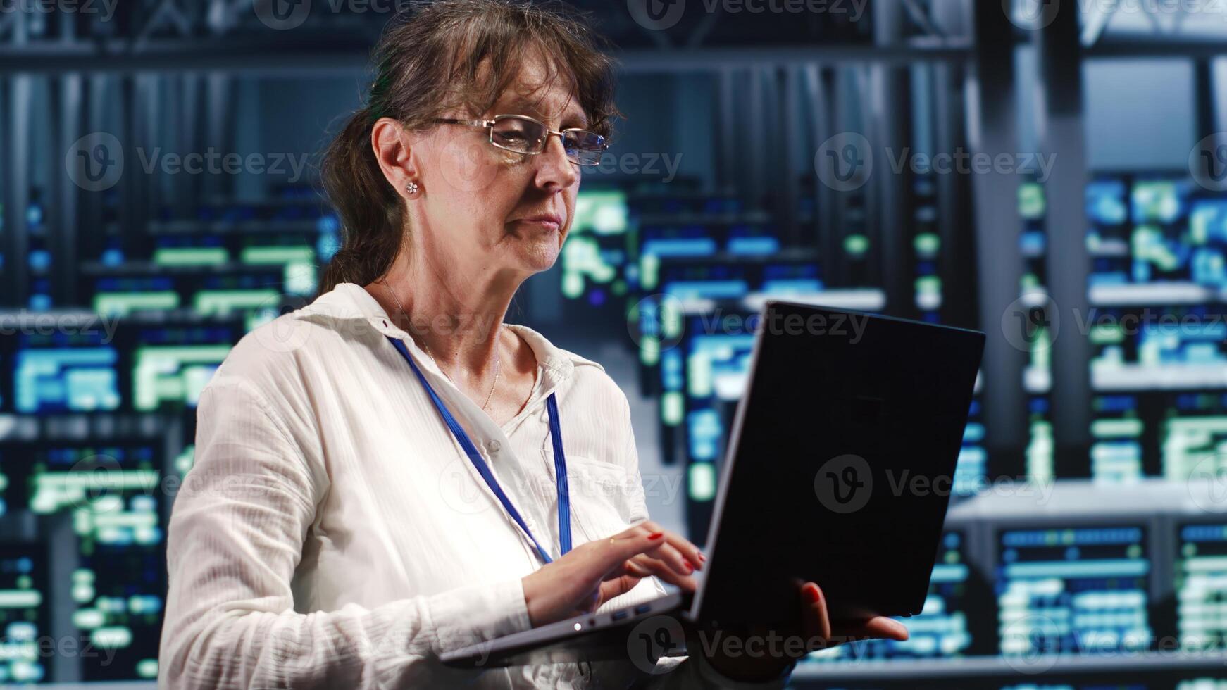 Senescent admin in high tech facility equipped to handle modern computing requirements, doing regular upgrades to blade servers, increasing processing power and storage capacity to prevent damages photo
