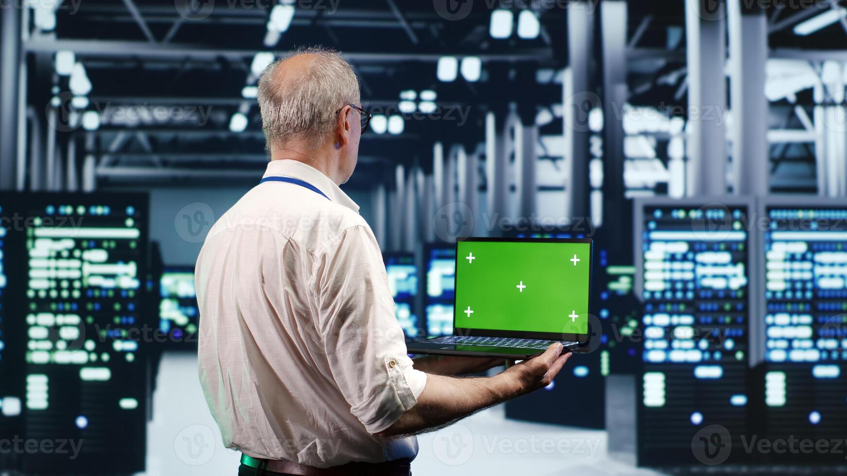 Knowledgeable IT professional navigating network of server racks in industrial hub. Repairman using green screen laptop, ensuring sound operations, doing optimizations and maintenance in data center photo