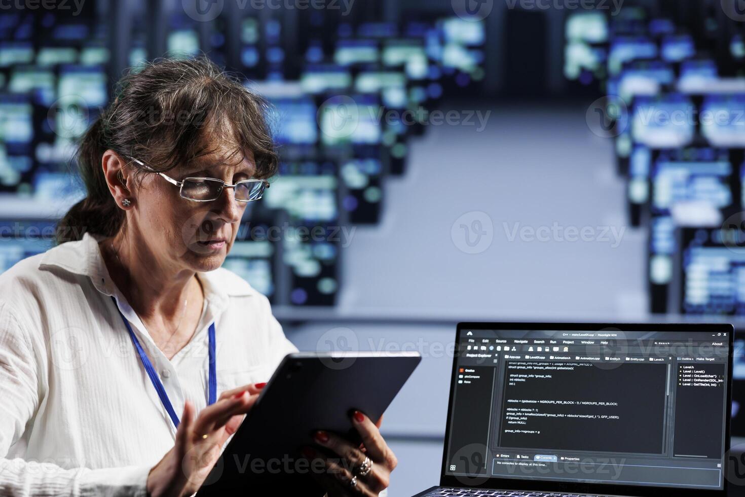 Old computer scientist writing script code in data center on laptop terminal. Adept professional doing maintenance work in server room, updating rigs software to prevent malfunctions photo